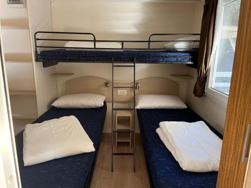 阿梅利亚Chalet Camping River Italië met 2 slaapkamers的拖车小房间设有两张双层床