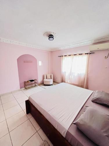 科纳克里Dubaï to Conakry KIPE的一间大卧室,配有一张大床和一把椅子