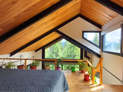 圣马丁德洛斯Casa de montaña La Cumba Patagonia.的一间带木制天花板和大窗户的卧室