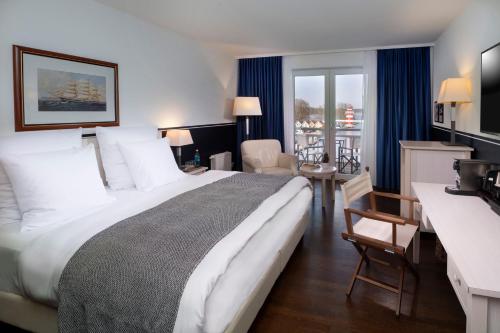 赖因斯贝格Precise Resort Hafendorf Rheinsberg的酒店客房设有一张大床和一张书桌。