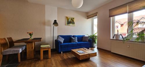普劳西Ferienwohnungen Altstadt的客厅配有蓝色的沙发和桌子