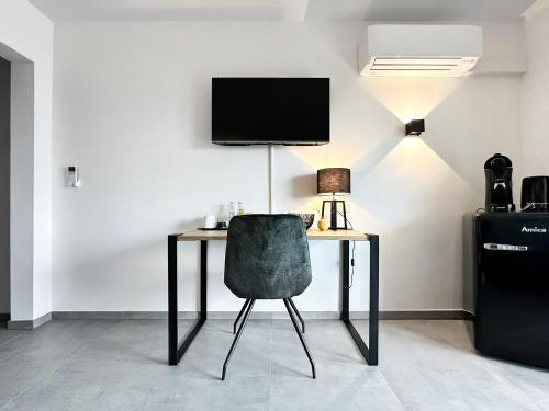 锡根Si-View Doppelzimmer mit Balkon Zimmer 1的一张桌子、椅子和墙上的电视