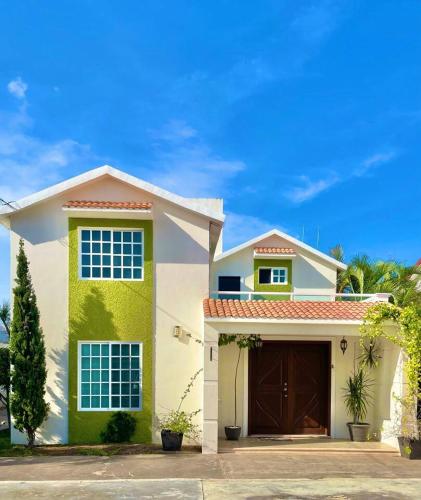 切图马尔Casa Coccoloba, Chetumal, Quintana Roo的白色绿色的房子,设有车库