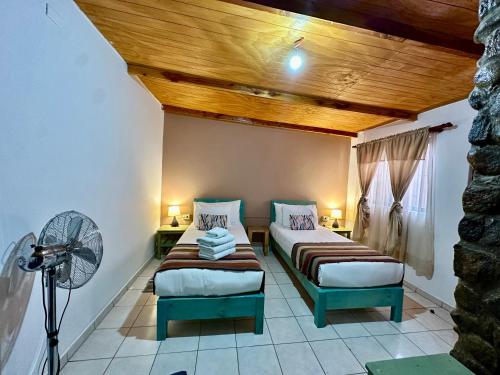 圣佩德罗·德·阿塔卡马Hostal Qachi Chentura的客房设有两张床和风扇。