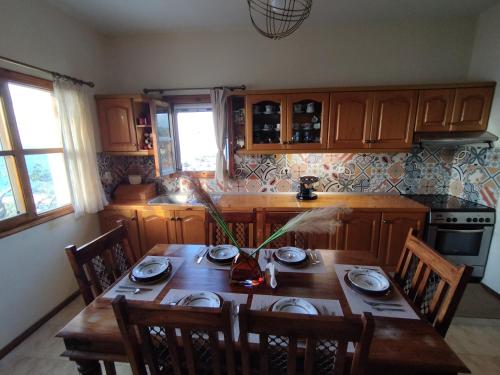 卡罗维西Laki's House的厨房配有木桌、椅子和桌子。