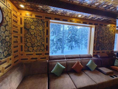 古尔马尔格Hotel Gulmarg Lux Shanum的带沙发和窗户的客厅