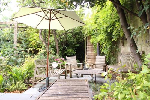 巴斯※ Relaxing Home- Parking & Gorgeous Gardens (TSG)※的庭院配有遮阳伞和桌椅。