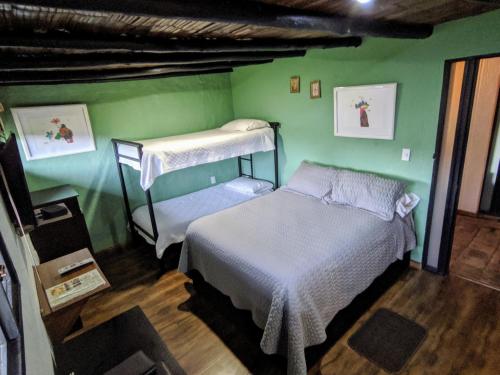 瓜斯卡果园咖啡旅馆的一间卧室设有两张双层床和绿色的墙壁