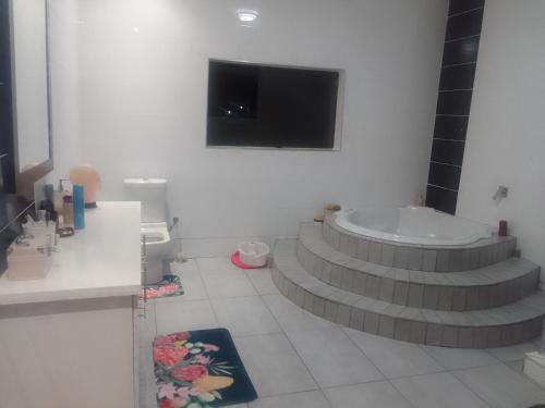 曼齐尼The Classic House B&B的一间带卫生间的浴室和墙上的电视