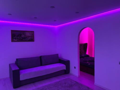 第聂伯罗Апартаменты Бульвар Славы 21的带沙发和粉红色照明的客厅