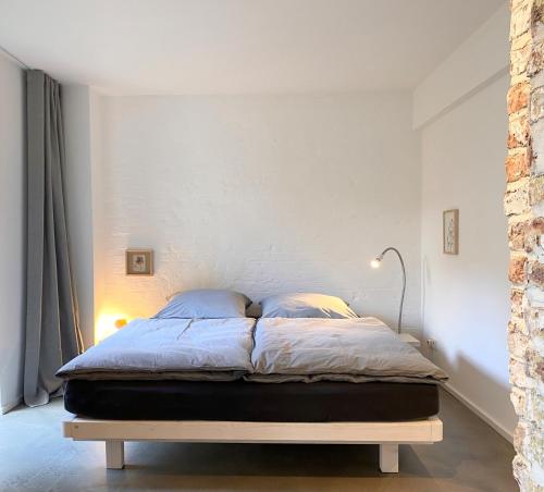 科隆Zehuus Gartenstudio mit Terrasse的卧室内的一张床位,卧室设有白色的墙壁