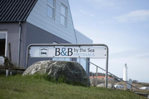 希茨海尔斯B&B by the Sea Hirtshals的海边和岩石旁的街道标志