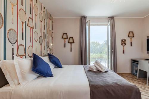 卡内利L'aja della Mirusina - Piedmont Resort Monferrato Langhe的卧室配有带蓝色枕头的大型白色床