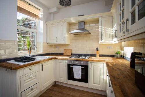 北希尔兹West Beck House - Newcastle 6的厨房配有白色橱柜和炉灶烤箱。