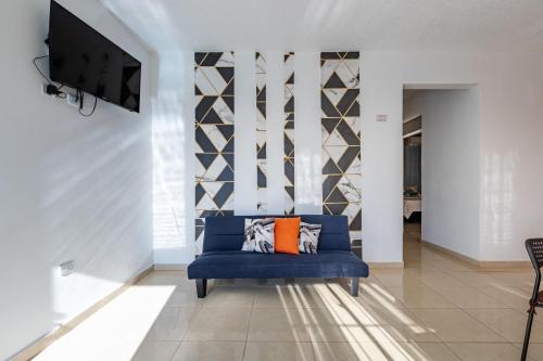 圣塔芭芭拉-山美纳EDMA APARTAHOTEL的客厅配有蓝色的沙发和电视