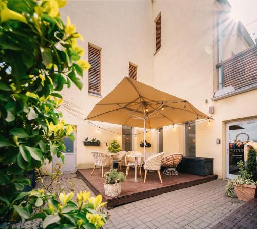 瓦尔季采Wine & Wellness hotel Besední dům的庭院配有桌椅和遮阳伞。