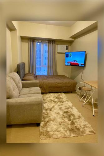 伊洛伊洛AVIDA ATRIA TOWER 3 Unit 3-320的带沙发和平面电视的客厅