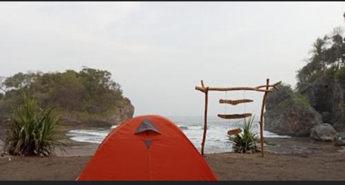 BulakbendaMadasari Outdoor Camping Tenda Paket Komplit的海边的红色帐篷
