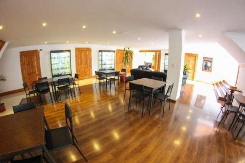 卡尔德拉Hotel 5° Estación的客厅铺有木地板,配有桌椅。