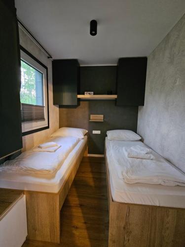 韦莱涅Mobilna hiška pod Lipo的小型客房 - 带2张床和窗户