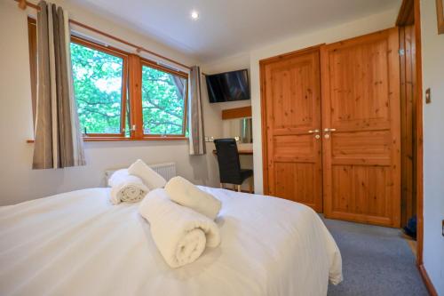 查德利Lodge Nine - A Beautiful Holiday Home in Devon的卧室配有白色床和毛巾