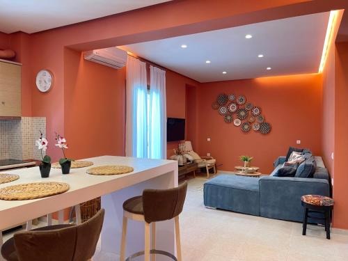 阿菲托斯Cynthia - Christine's House的客厅设有橙色墙壁和蓝色沙发