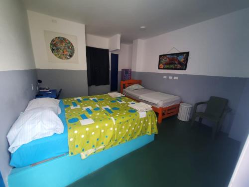 卡塔赫纳Hotelito La Aventura, private rooms with AC的一间卧室配有一张黄色和蓝色的被子。