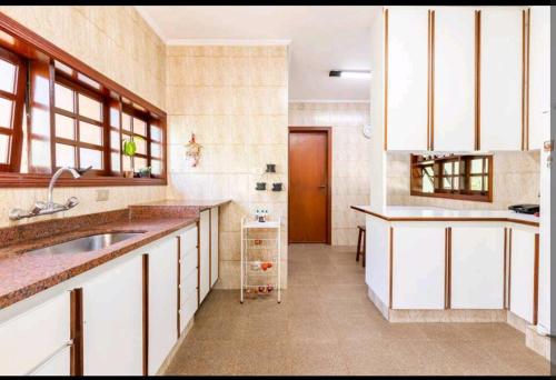 科蒂亚Casa na Granja Viana - Cotia的一间大厨房,配有白色的橱柜和水槽