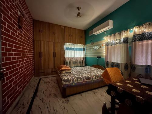 巴特那Amma’s Om stay的一间卧室设有一张床和砖墙