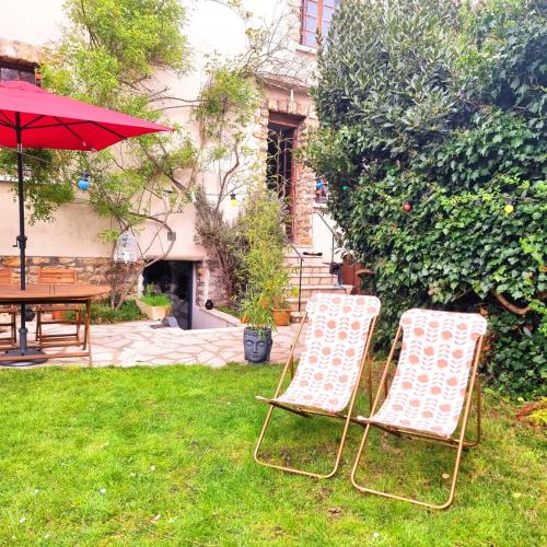克劳德LA CAMPAGNE à PARIS的院子里有两把椅子、一张桌子和一把伞
