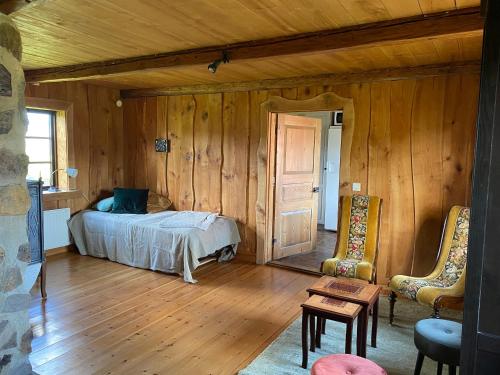 TollarpTorpet的卧室配有一张床铺,位于带木墙的房间内
