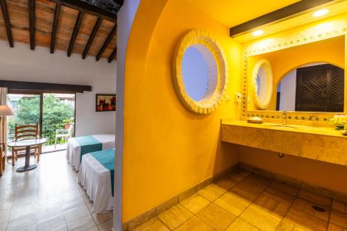 巴亚尔塔港布埃纳文图拉庄园墨西哥魅力酒店 - 全包 的浴室设有黄色墙壁和水槽