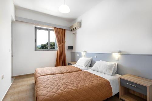 伊利索斯Anixis Hotel & Apartments的一间卧室设有两张床和窗户。