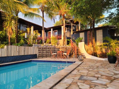 巴伊亚福尔莫萨Arandu Sagi Inn的一座带游泳池和棕榈树的房子