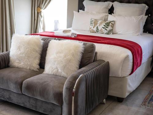 雾观Khutso Boutique Hotel的一间卧室配有一张床和一张带枕头的沙发。