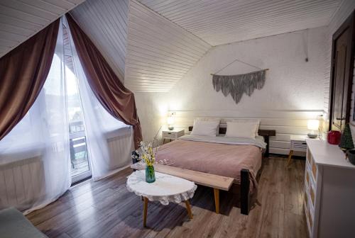 斯拉夫西克Захарова Оселя的一间卧室配有一张大床和一张桌子