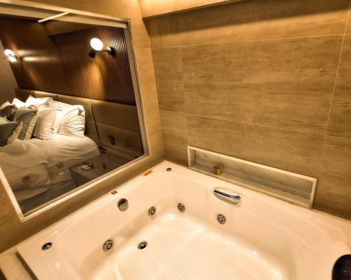 贝洛奥里藏特贝洛奥里藏特卢尔德希尔顿花园酒店的浴室配有浴缸及镜子