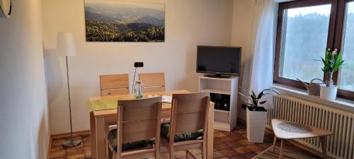 塞埃巴克Ferienhof Fischer的客厅配有桌子和电视
