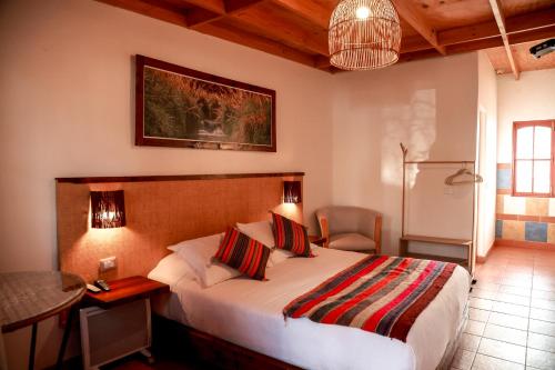 圣佩德罗·德·阿塔卡马Tambo Atacama Lodge的一间卧室配有一张床、一张桌子和一张桌子