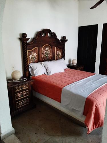 库埃纳瓦卡H Boutique Edén Cuernavaca的一间卧室配有一张大床和木制床头板