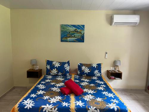 MaroeTuna House的一间卧室配有蓝色的床和两个红色枕头