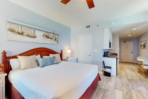 巴拿马城海滩Splash Resort 1901W Suite A Studio的一间带大床的卧室和一间厨房