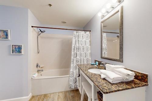 巴拿马城海滩Splash Resort 1901W Suite A Studio的一间带水槽、浴缸和镜子的浴室
