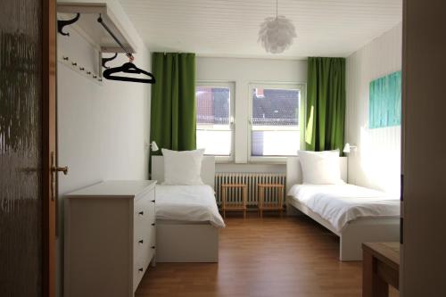 汉诺威Centrally located 2-room apartment的一间卧室设有两张床和绿色窗帘