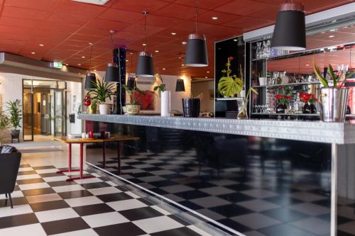 哈尔姆斯塔德Halmstad Hotel Apartments的一间位于餐厅内的酒吧,餐厅设有一层格子