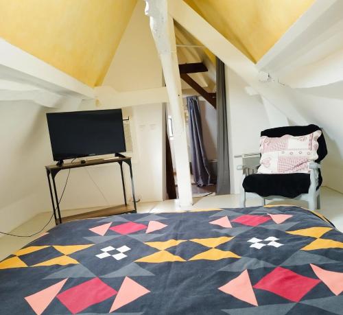 维朗德里埃皮策里高曼德酒店的一间卧室配有一张床,并在一间客房内配有电视。