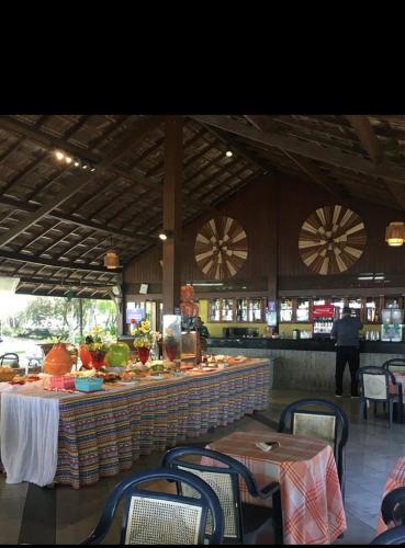塞古罗港Resort All Inclusive Arcobaleno的餐厅内的酒吧配有桌椅
