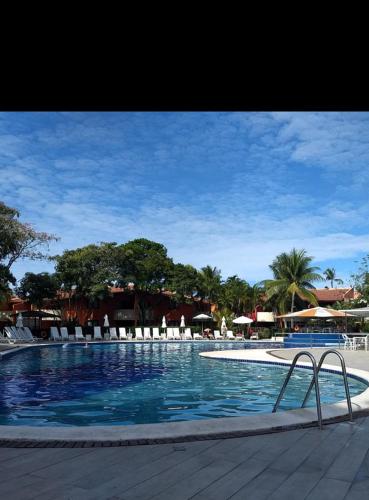 塞古罗港Resort All Inclusive Arcobaleno的一个带椅子和遮阳伞的大型游泳池