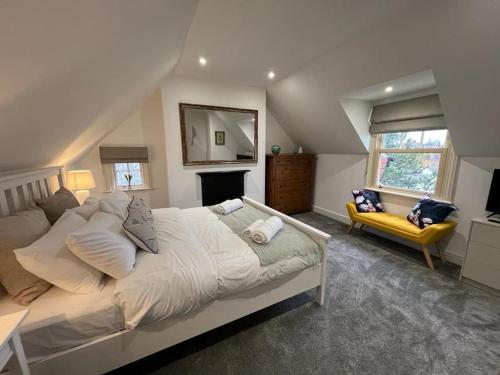 梅尔顿莫布雷The Loft at Scalford House的一间卧室配有一张大床和一张黄色的沙发