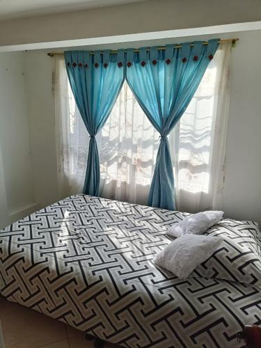 波哥大San antonio urbano的一张带蓝色窗帘的床和窗户